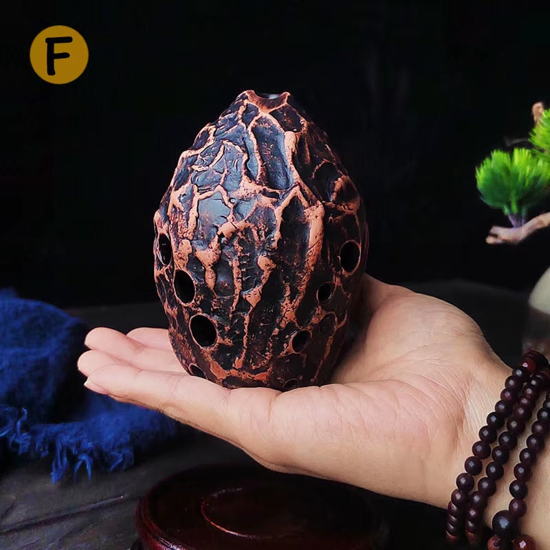 Decorative copper-colored egg with intricate honeycomb pattern for 10-Hole Pottery Xun