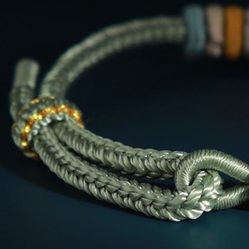 Bracelet à quatre brins avec fil rouge et fleur de pêcher