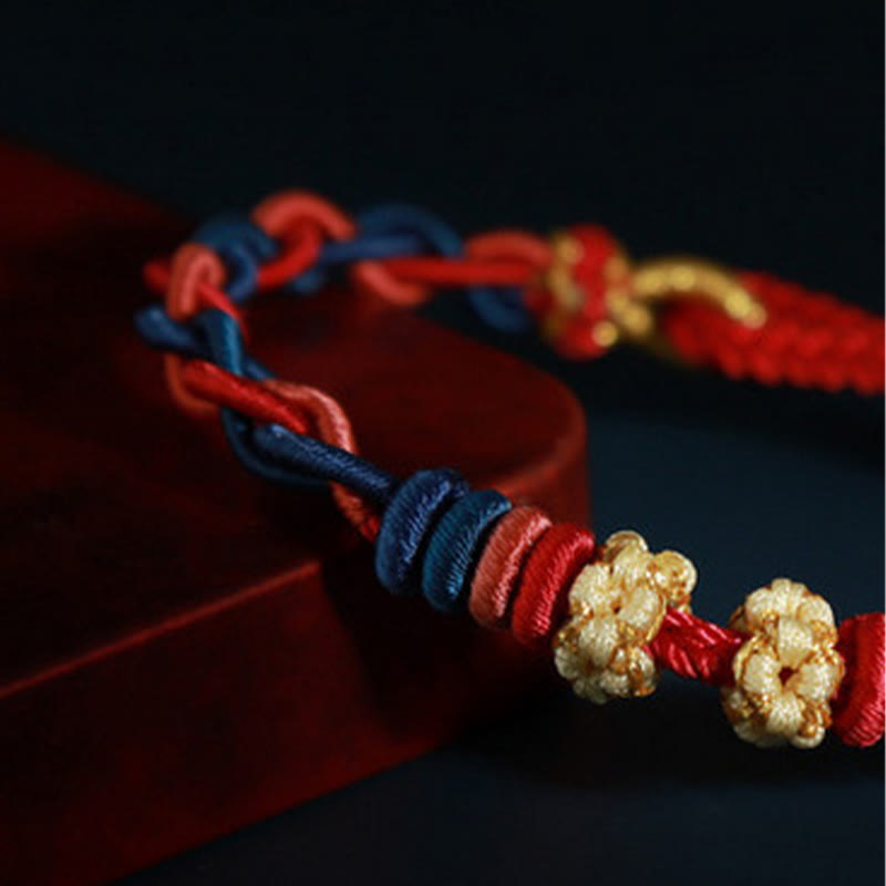 Bracelet à quatre brins avec fil rouge et fleur de pêcher