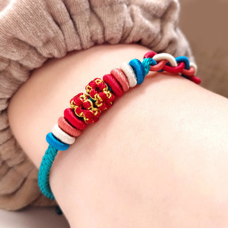 Bracelet à quatre brins avec fil rouge et fleur de pêcher