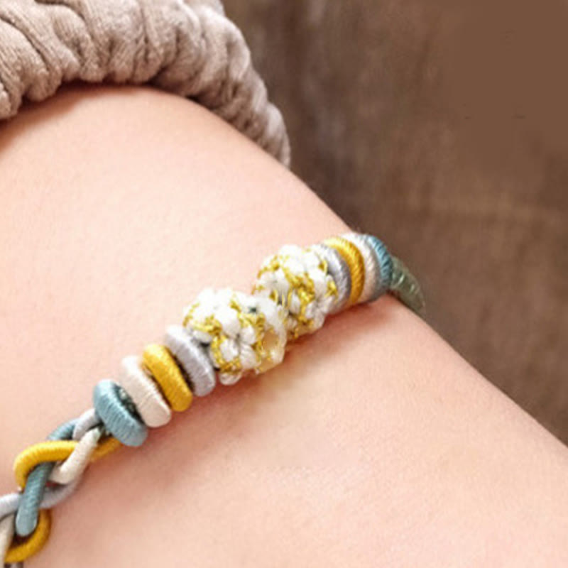 Bracelet à quatre brins avec fil rouge et fleur de pêcher
