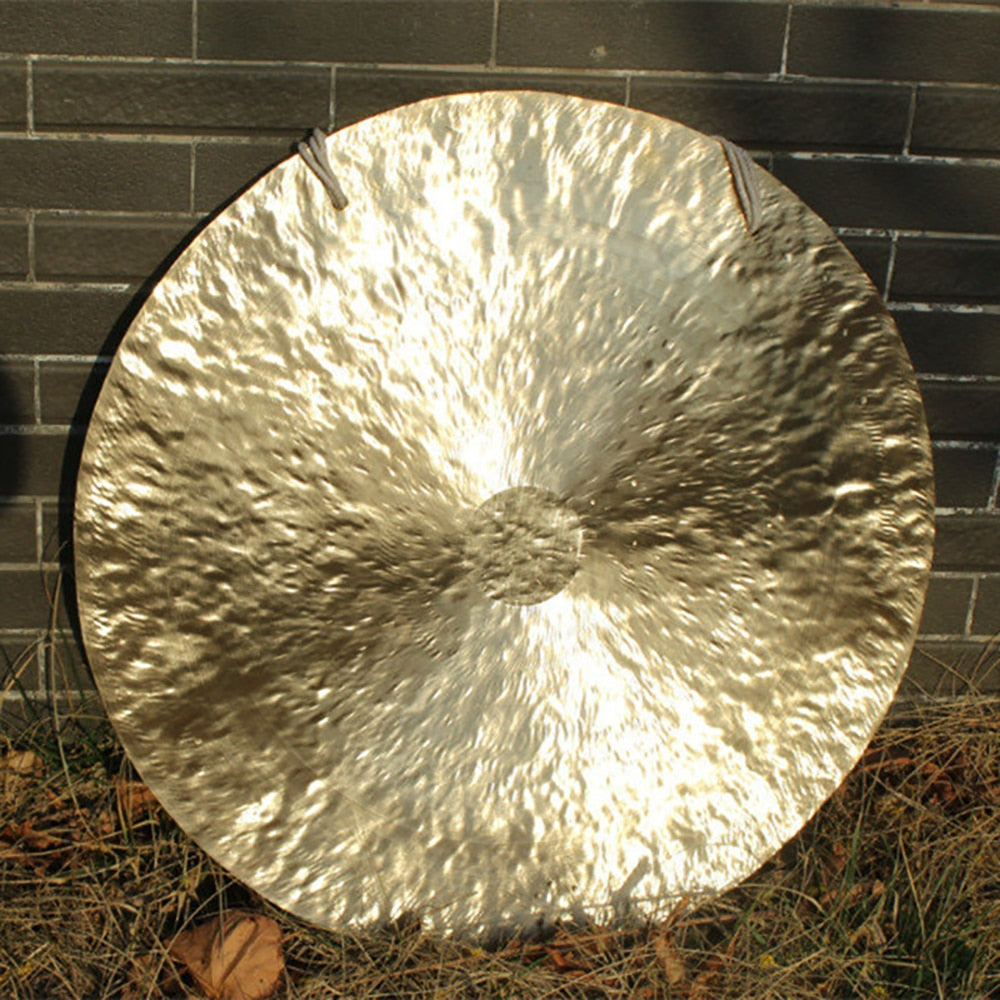 Circular metallic gong with hammered texture, reflecting light in 38 Inch Chinese Wind Gong