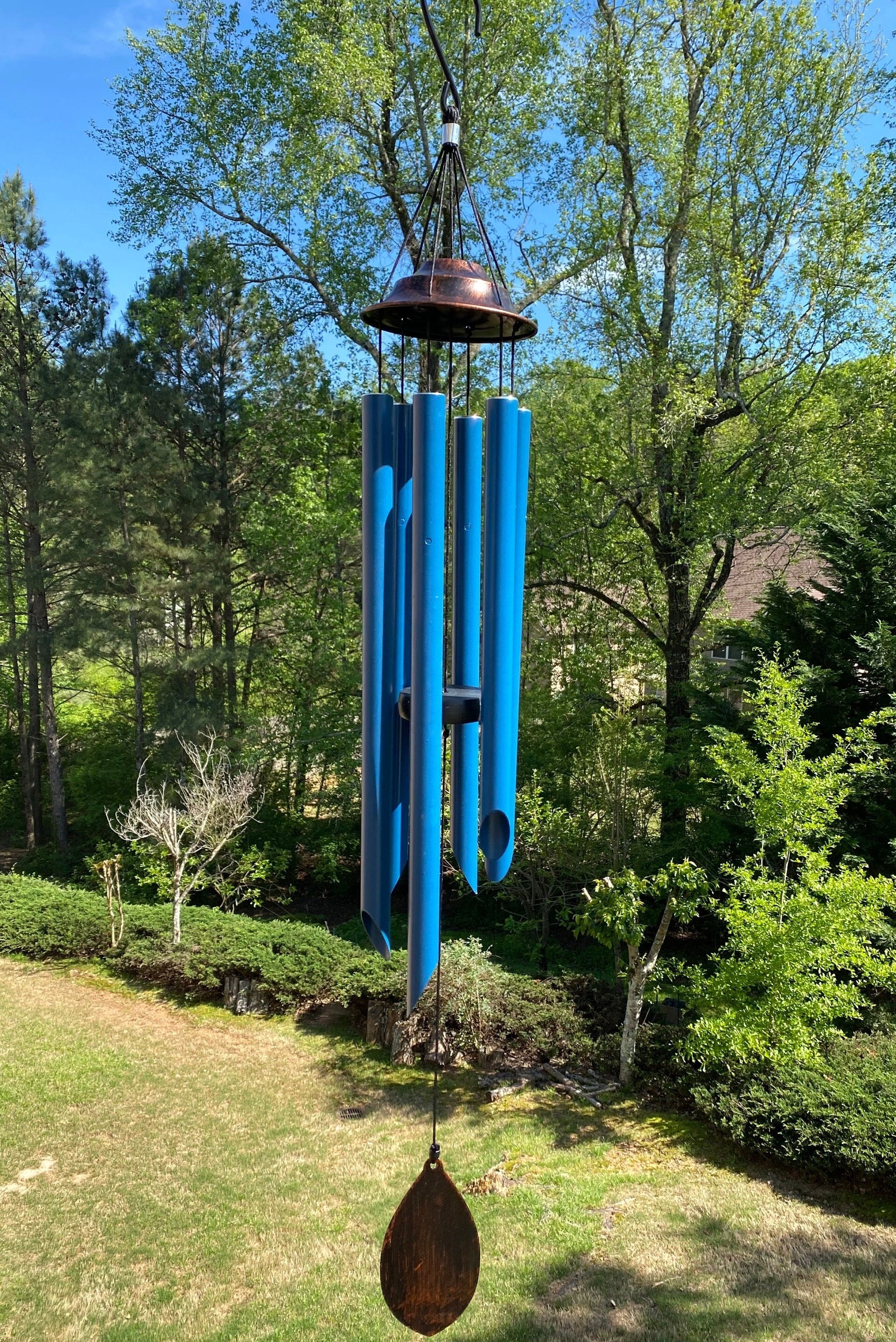 Bright blue wind chime with metal tubes and wooden striker for outdoor decoration