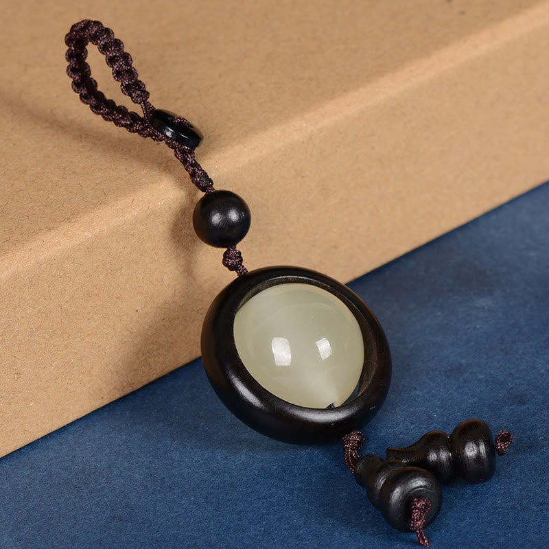 Porte-clés en bois d'ébène « Paix » | Perles lumineuses en bois de santal rouge et vert