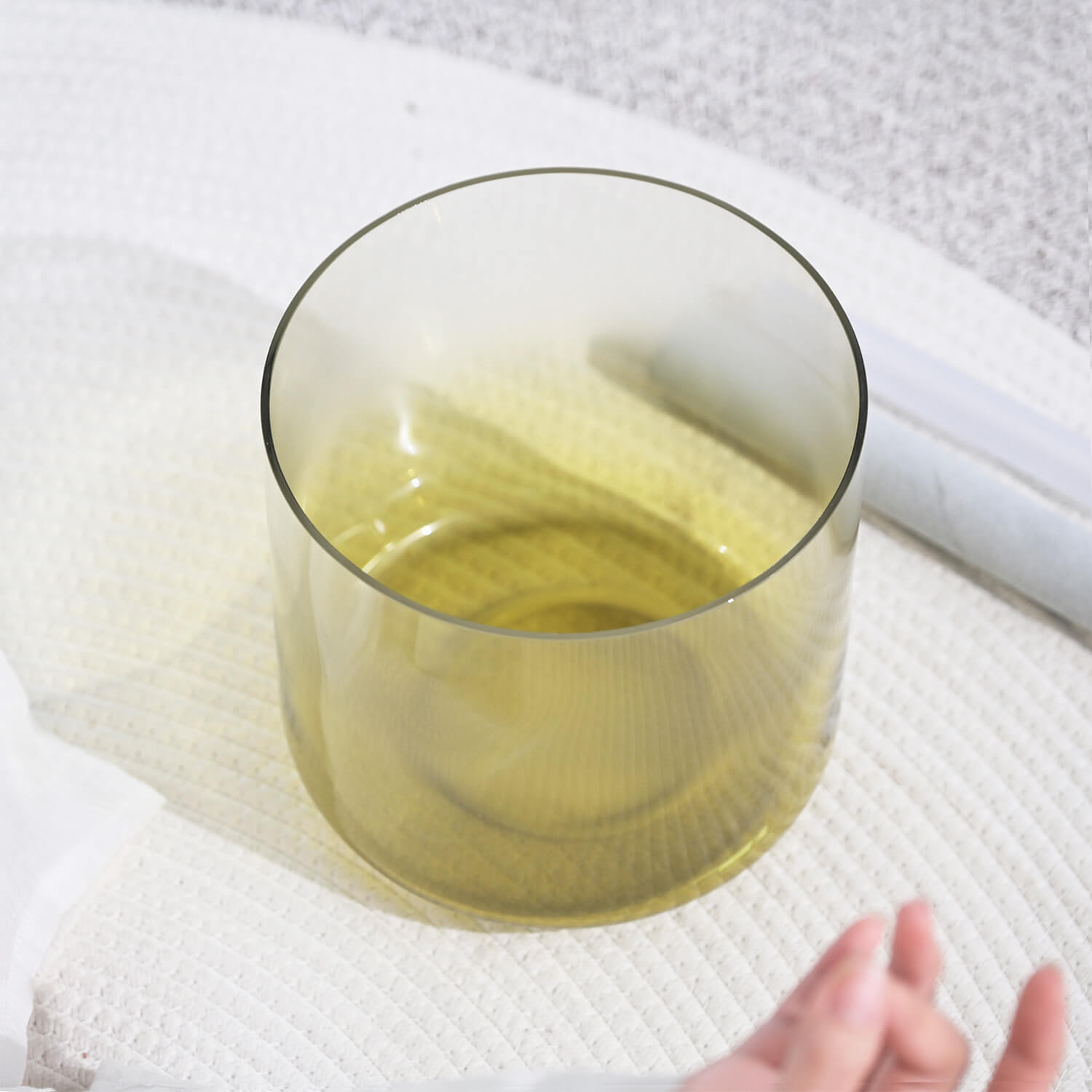 Glass tumbler with yellow liquid beside 6/7’’ Quartz Crystal Singing Bowl for meditation