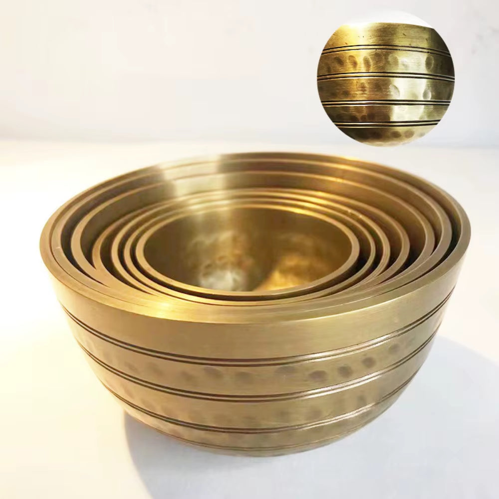 Nested gold metallic bowls with ridged bands in a Tibetan Singing Bowl Set for Meditation