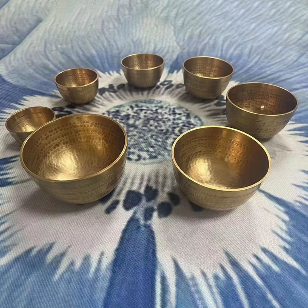 Seven brass singing bowls in a circular arrangement for meditation practice