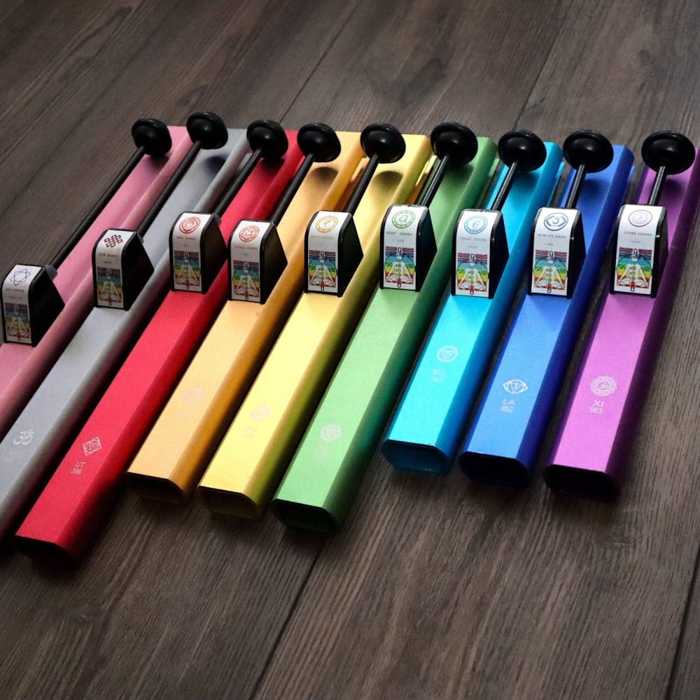 Rainbow-colored disposable vape pens arranged in a row with a metal case