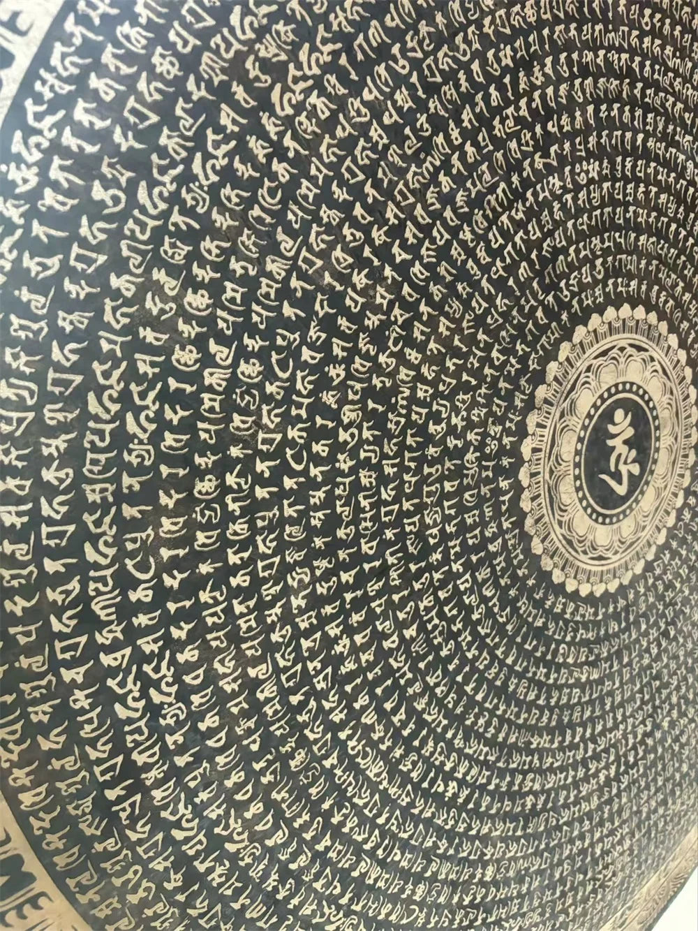 Circular pattern of Sanskrit text radiating from a medallion on Ancient Chau Gong