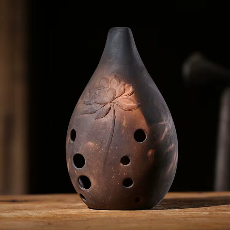 Teardrop-shaped ceramic vase with carved lotus design and holes for Ceramic Xun instrument