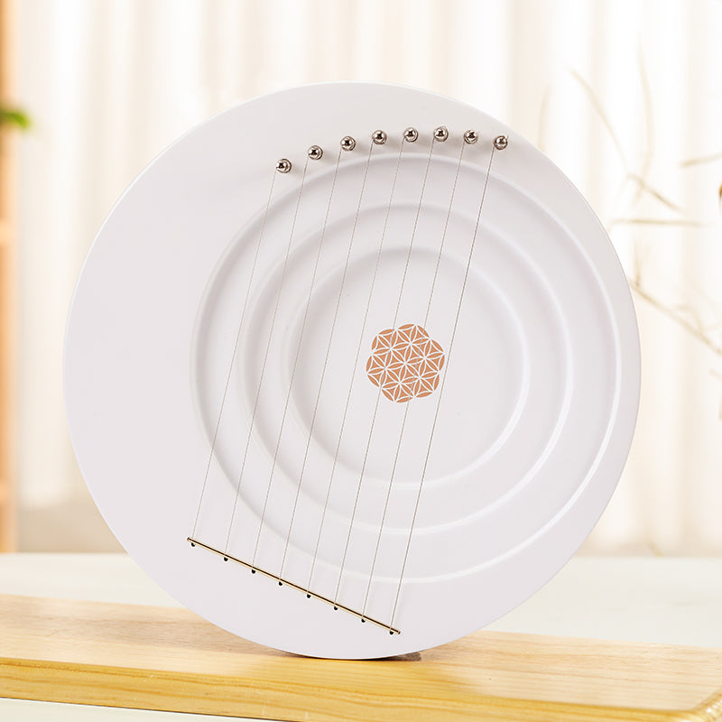White ceramic plate with metallic strings and geometric design for Full Moon Lyre Harp