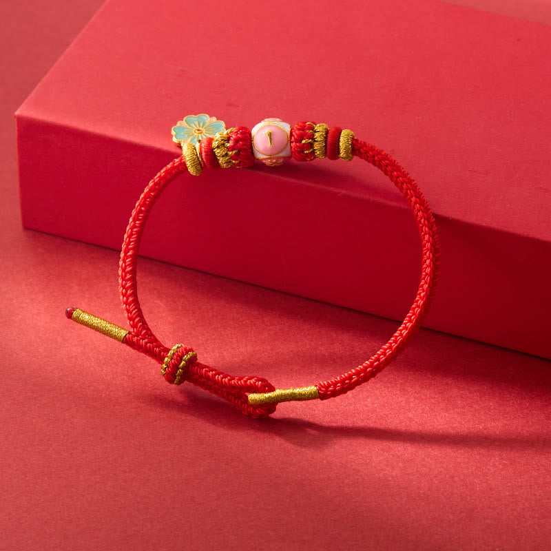 Bracelet de protection en cuivre plaqué or et fil rouge en forme de fleur de pêcher