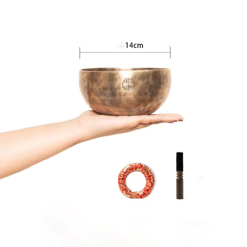 Hand-hammered Tibetan singing bowl featuring traditional Buddhist symbols for meditation