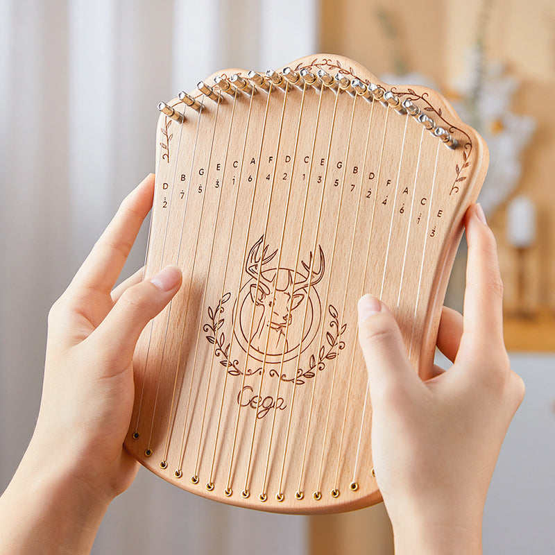 Wooden 17-string lyre harp with engraved deer head design and tuner