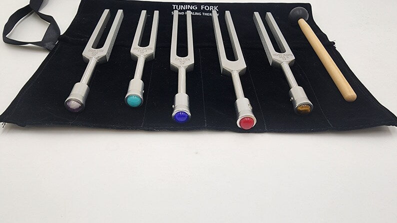 Set of colorful tuning forks in a black fabric case for sound therapy