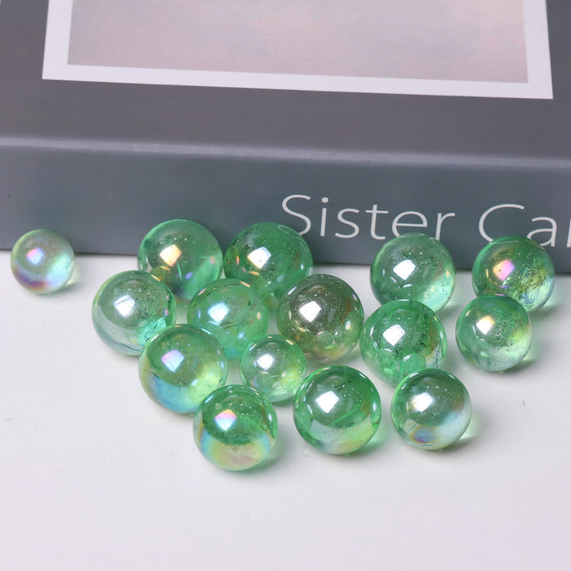 Iridescent green glass marbles in a polished Aura Green Crystal Sphere healing orb