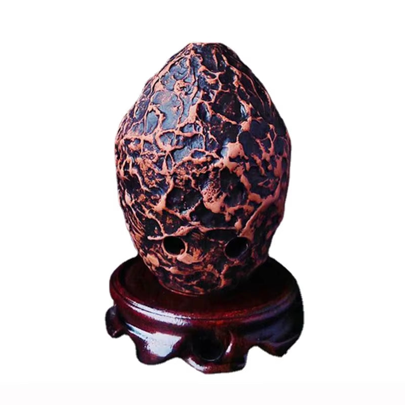 Crackled reddish-copper egg-shaped object on wooden stand for 10-Hole Pottery Xun