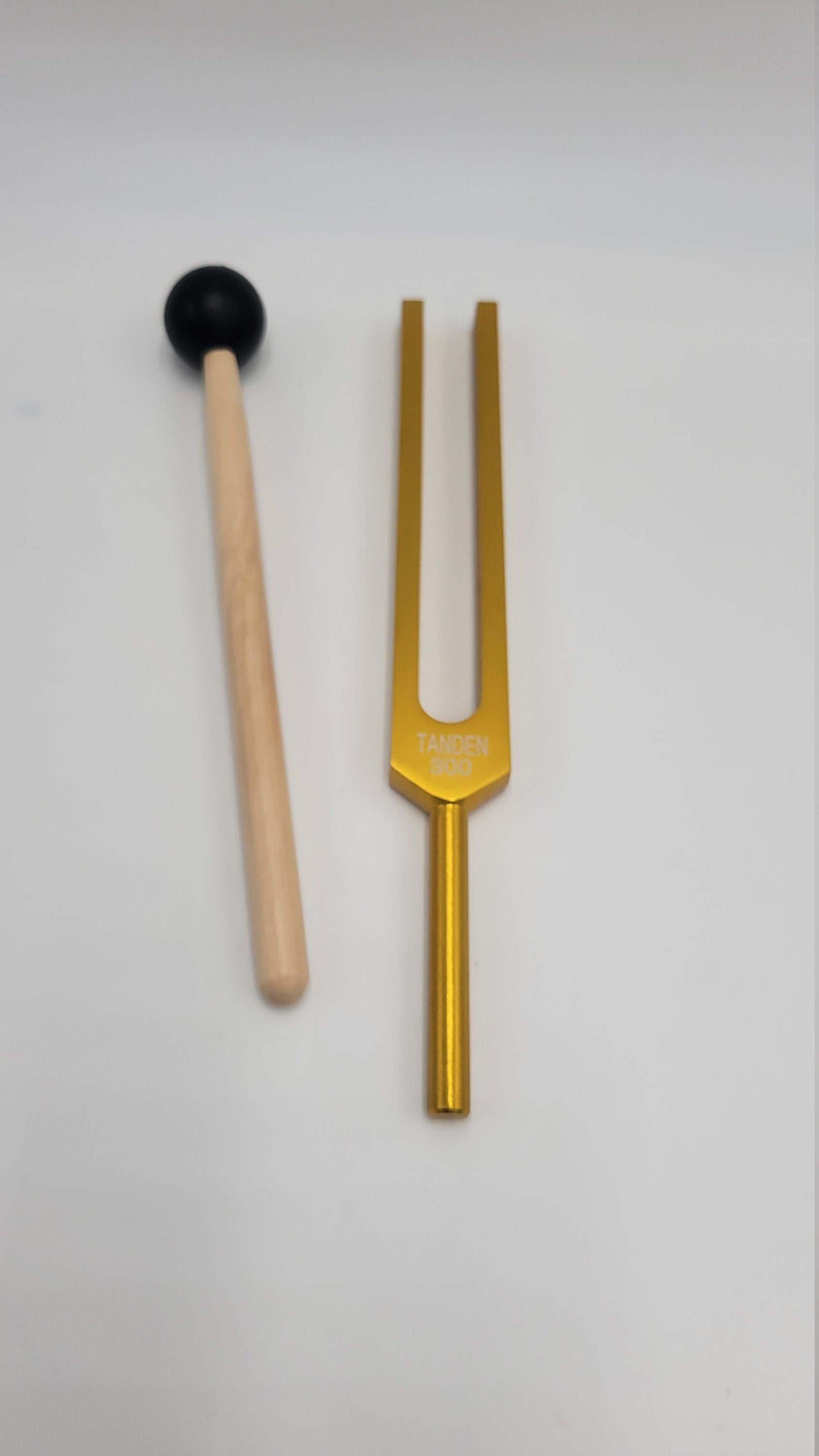 Golden tuning fork with wooden mallet for 300 Hz Dan Tien energy healing