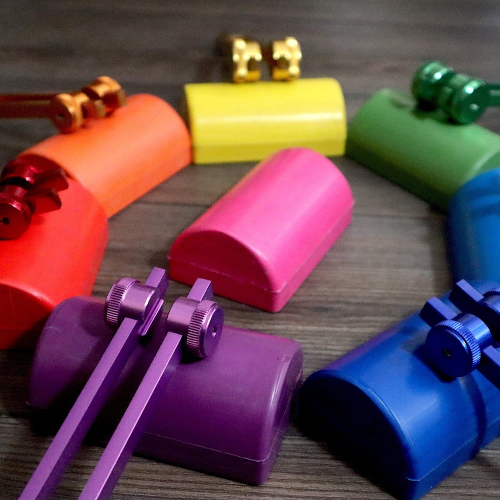 Colorful plastic kazoos arranged in a rainbow for 528 Hz Solfeggio Tuning Fork product