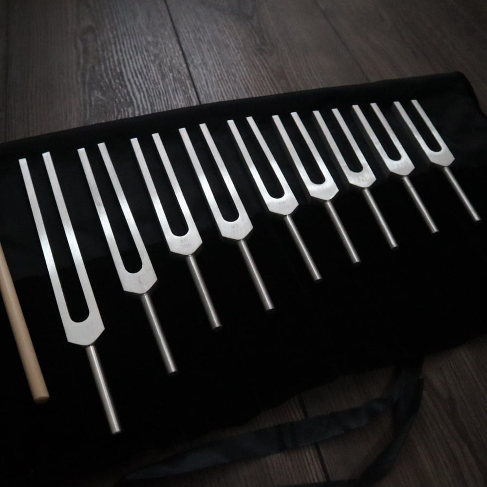 Collection of tuning forks on black fabric from 9pc Solfeggio Frequencies Set