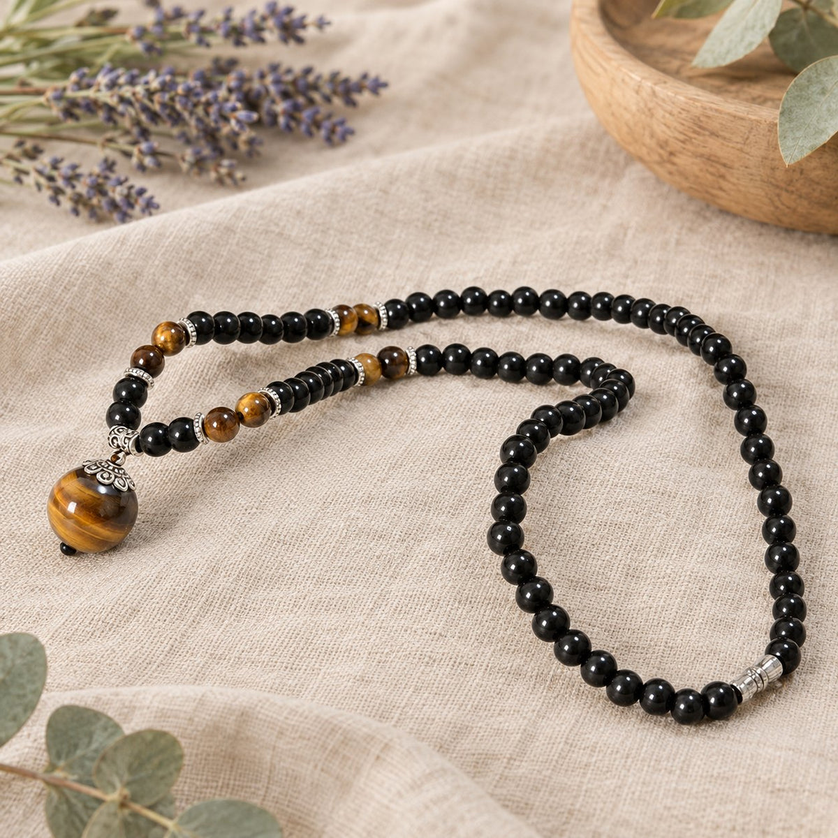 Black Obsidian Tiger Eye Necklace for Protection & Strength, necklace laid in a loop in a shell dish