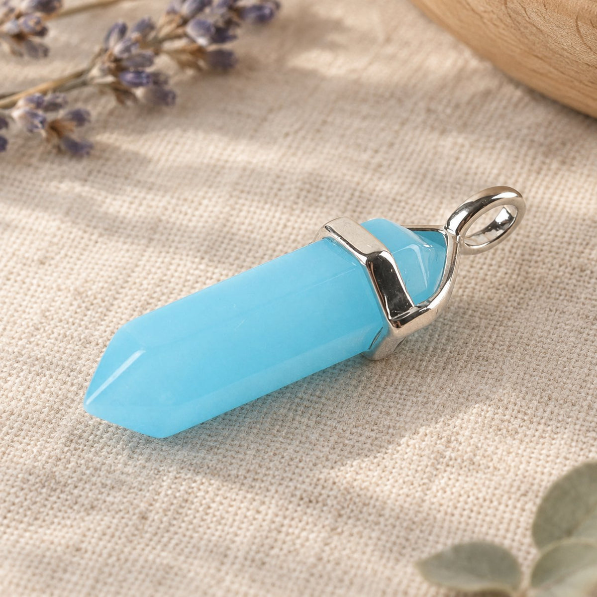 Blue Luminous Spiritual Pendant 1-1/2 inch Healing Crystal, angled view of the pendant lying, bail visible