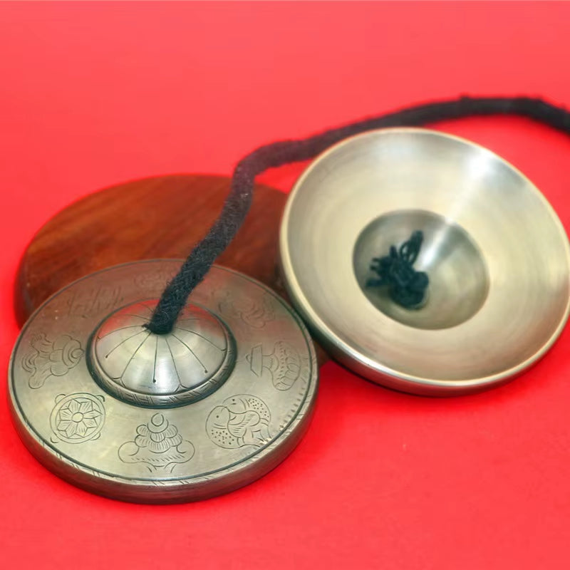 Tibetan meditation cymbals with decorative engravings and connecting cord for meditation