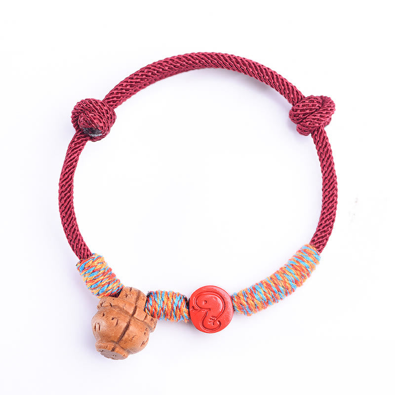 Bracelet porte-bonheur en fil rouge et cinabre avec noyau de pêche et symbole du zodiaque chinois
