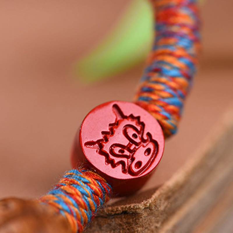 Bracelet porte-bonheur en fil rouge et cinabre avec noyau de pêche et symbole du zodiaque chinois