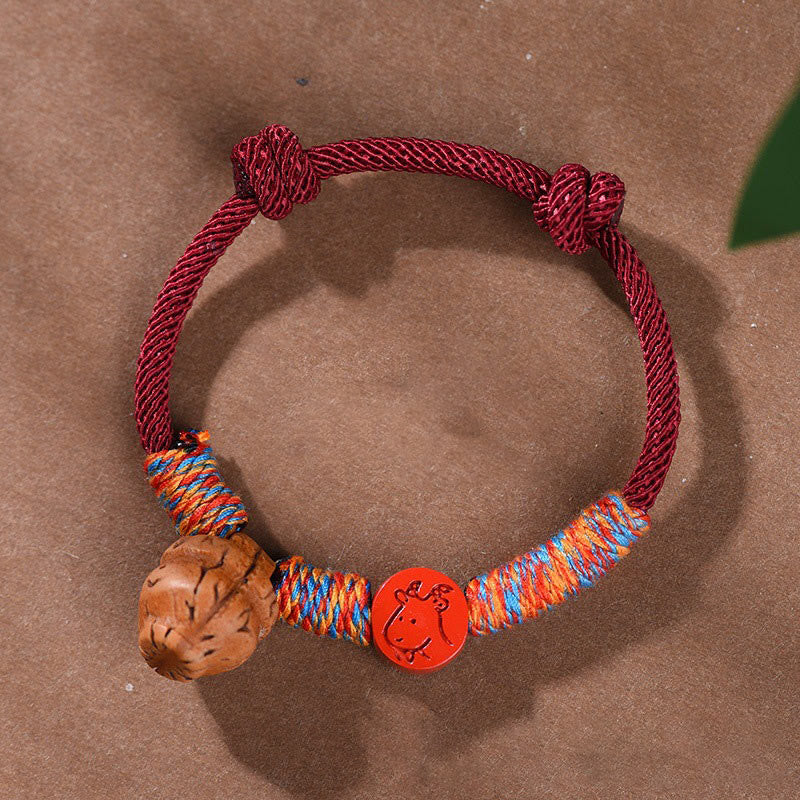 Bracelet porte-bonheur en fil rouge et cinabre avec noyau de pêche et symbole du zodiaque chinois