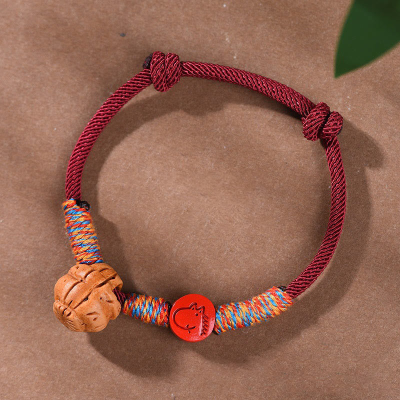 Bracelet porte-bonheur en fil rouge et cinabre avec noyau de pêche et symbole du zodiaque chinois