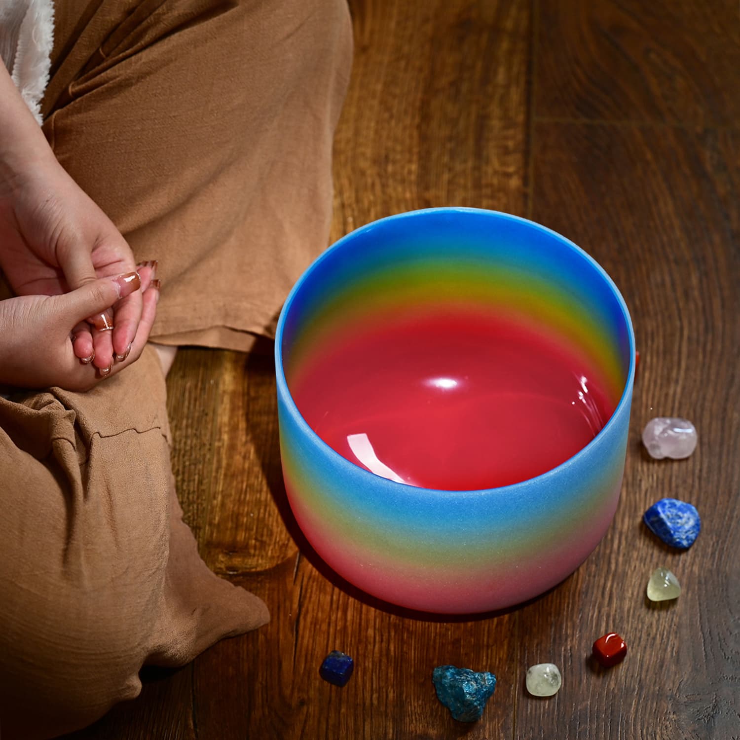 Rainbow-colored ceramic bowl with red liquid for Crystal Singing Bowl G Note sound healing