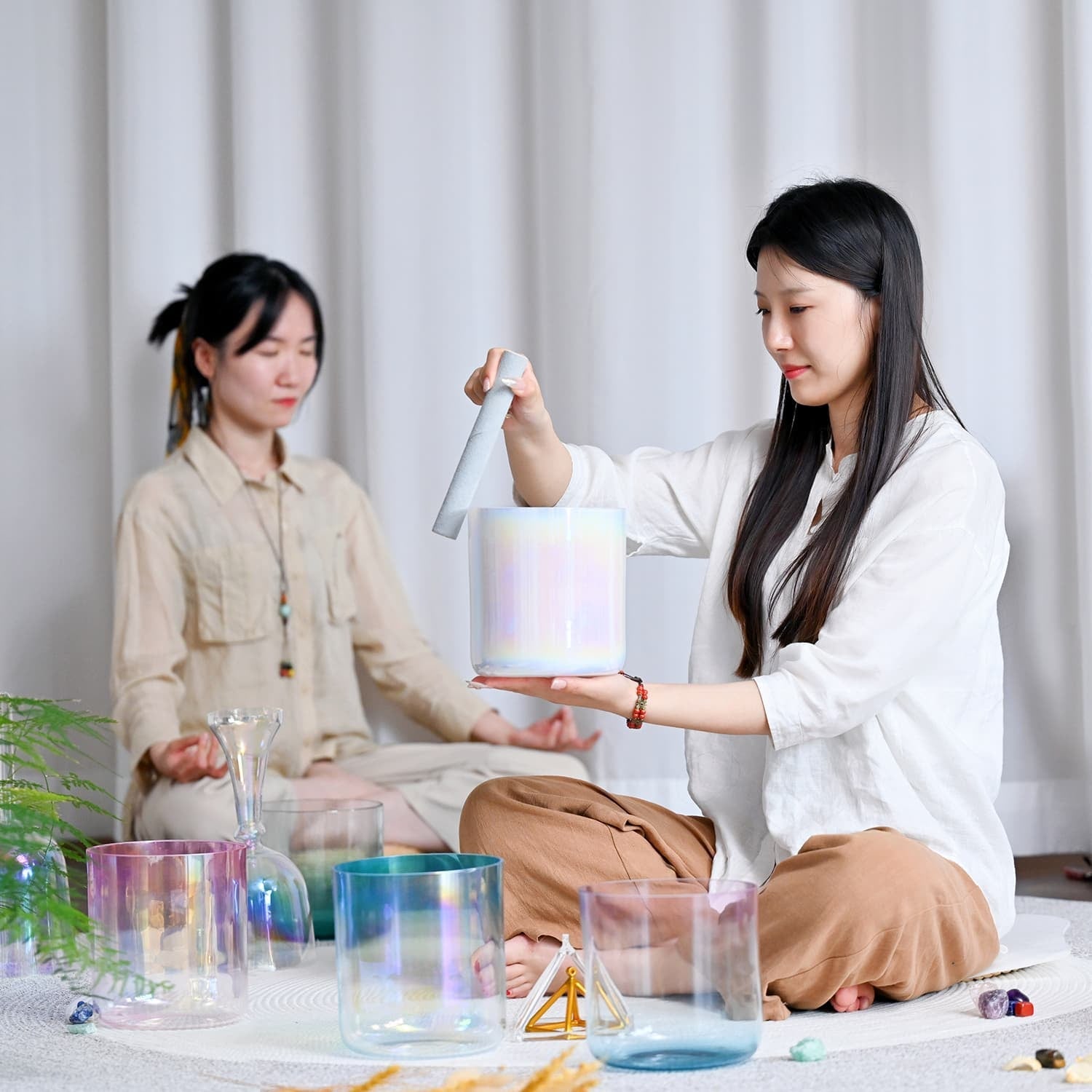 Two people meditating with crystals and ritual objects during a healing session