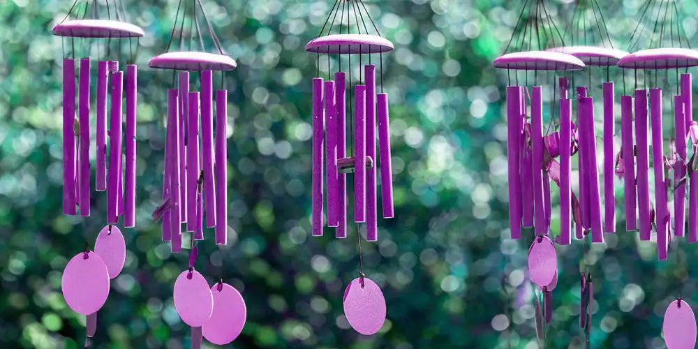 Purple wind chimes with cylindrical tubes and circular discs hanging from a central cap.