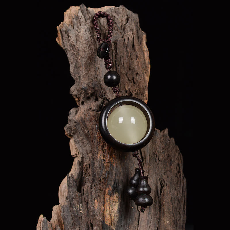 Porte-clés en bois d'ébène « Paix » | Perles lumineuses en bois de santal rouge et vert