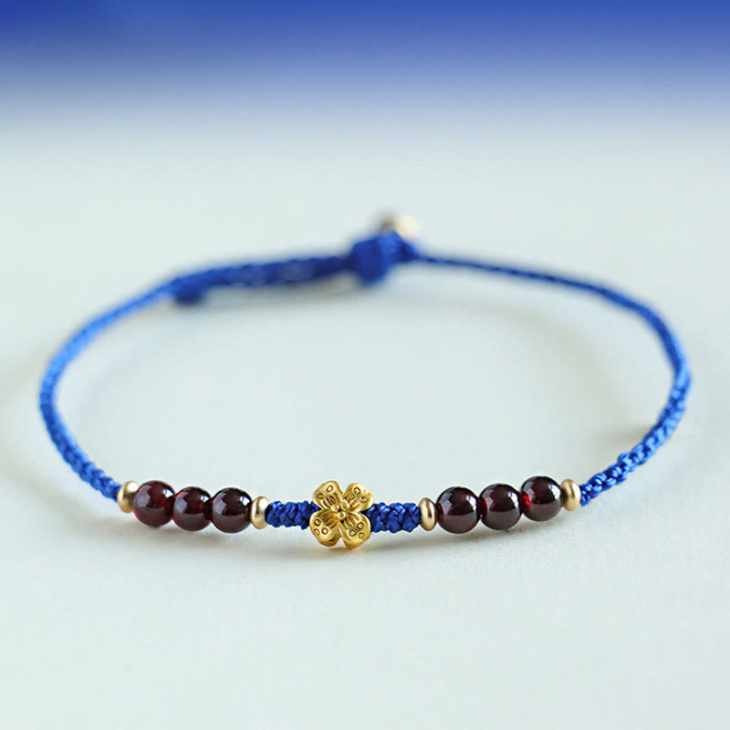 Bracelet fleur en cuivre et grenat sur fil bleu | Sons de guérison