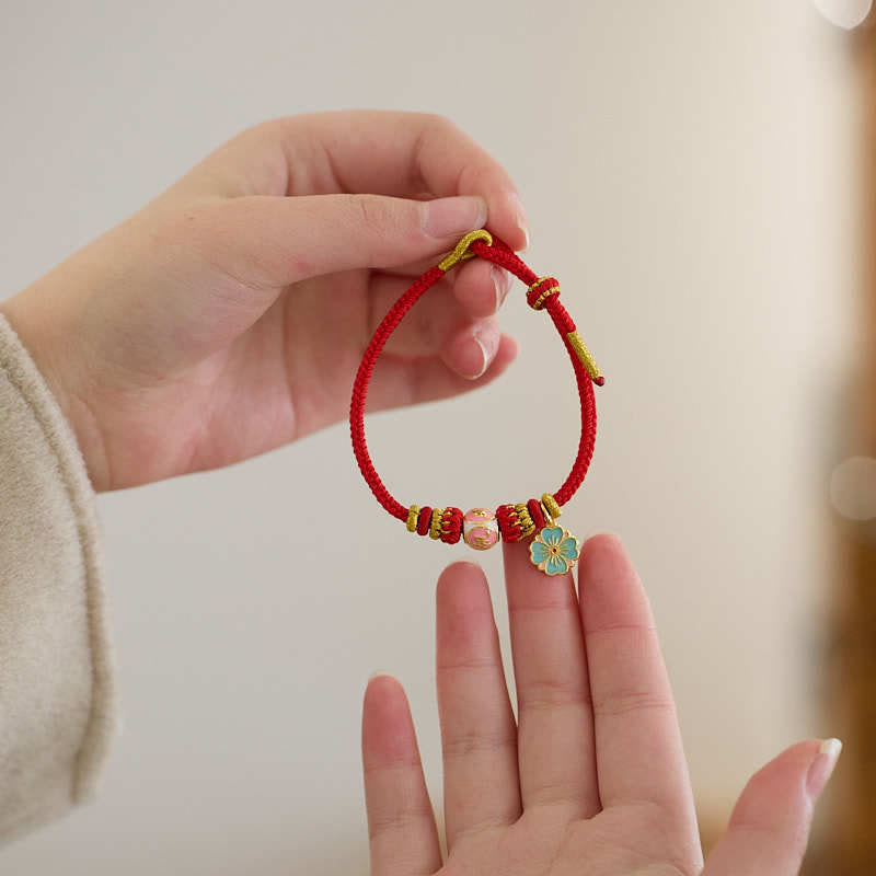 Bracelet de protection en cuivre plaqué or et fil rouge en forme de fleur de pêcher