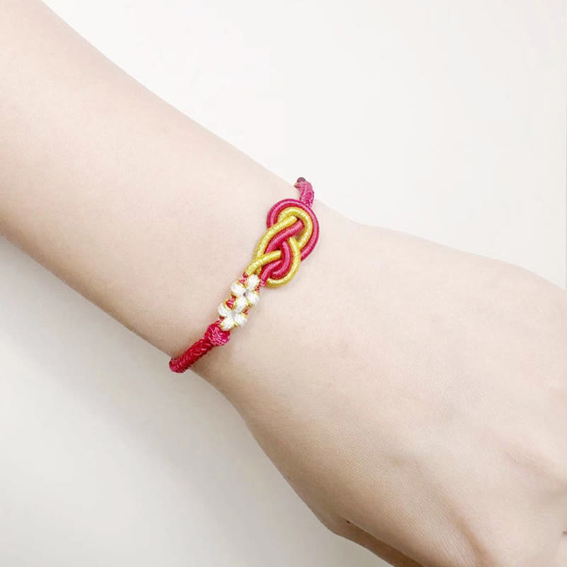 Bracelet artisanal à huit fils rouges avec nœud de paix