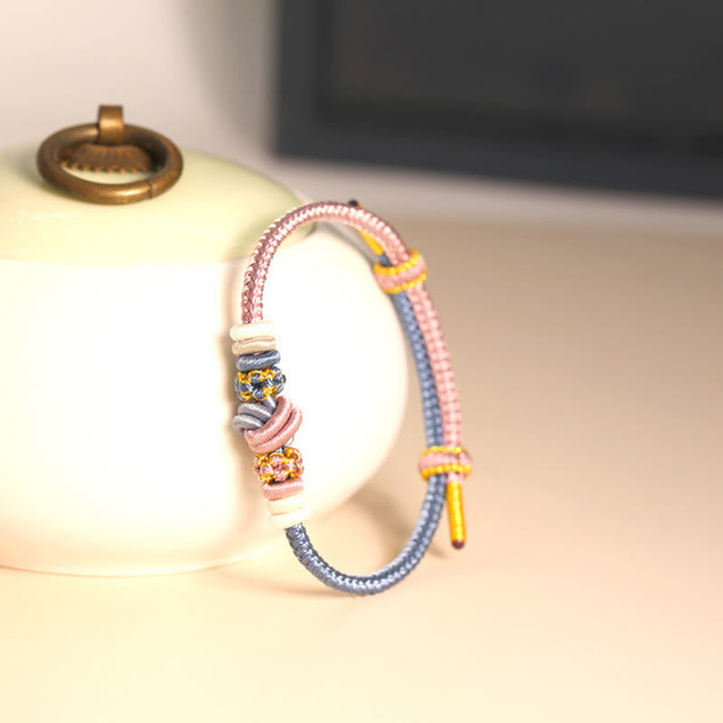 Bracelet en fil rouge bicolore avec nœud de paix fabriqué à la main