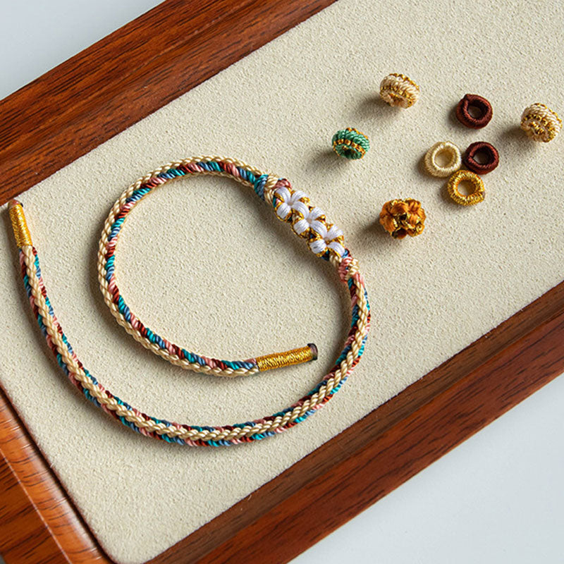 Bracelet en fil rouge à motif de fleurs de pêcher Dunhuang fait main