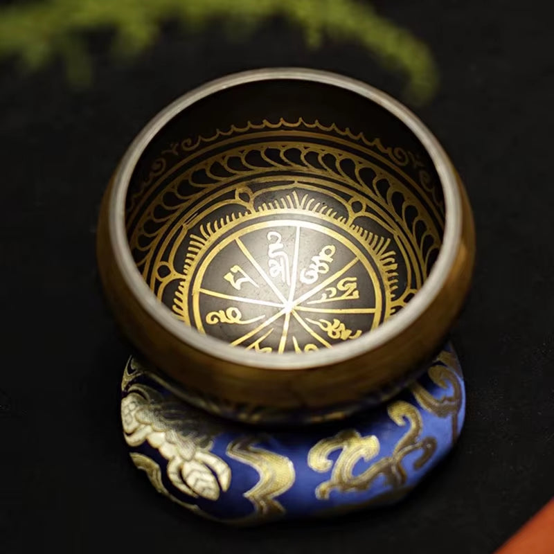 Decorative Handmade Tibetan Singing Bowl with gold compass on blue cushion