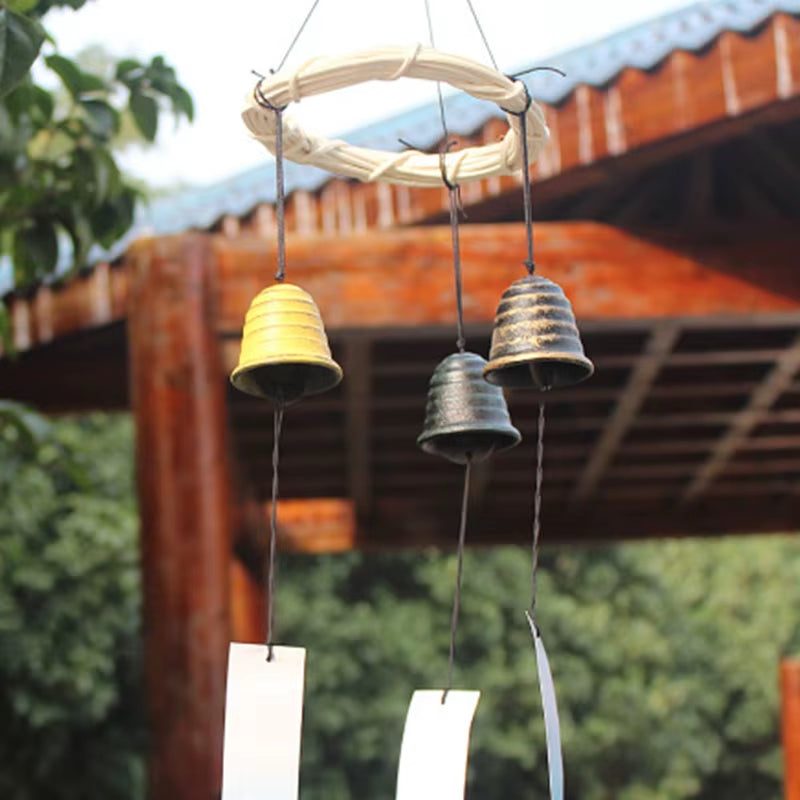 Japanese Cast Iron Wind Chimes with three bells hanging from a wooden frame for garden decor