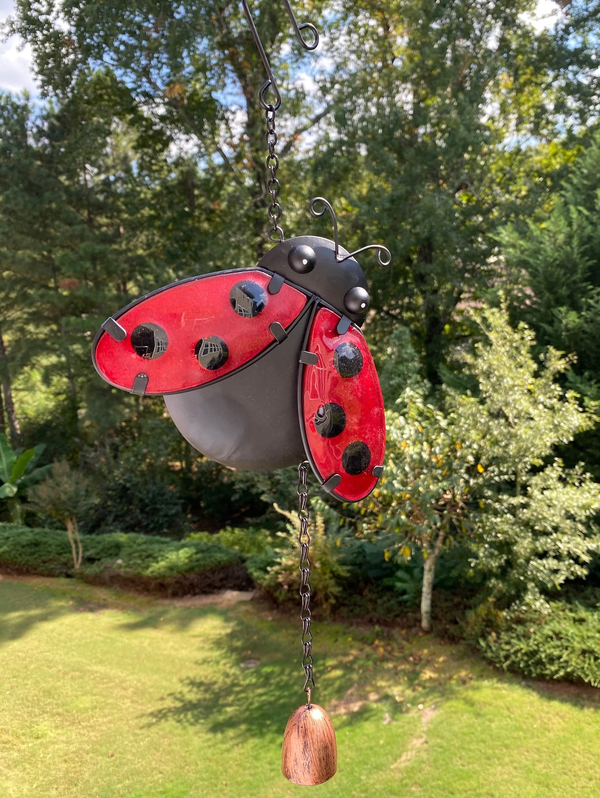 Red and black metal ladybug garden ornament with movable wings for outdoor decor