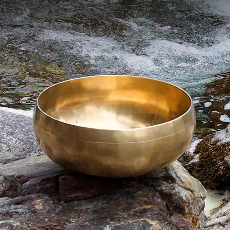 Golden Tibetan singing bowl on stone for sound healing in Nepalese craftsmanship