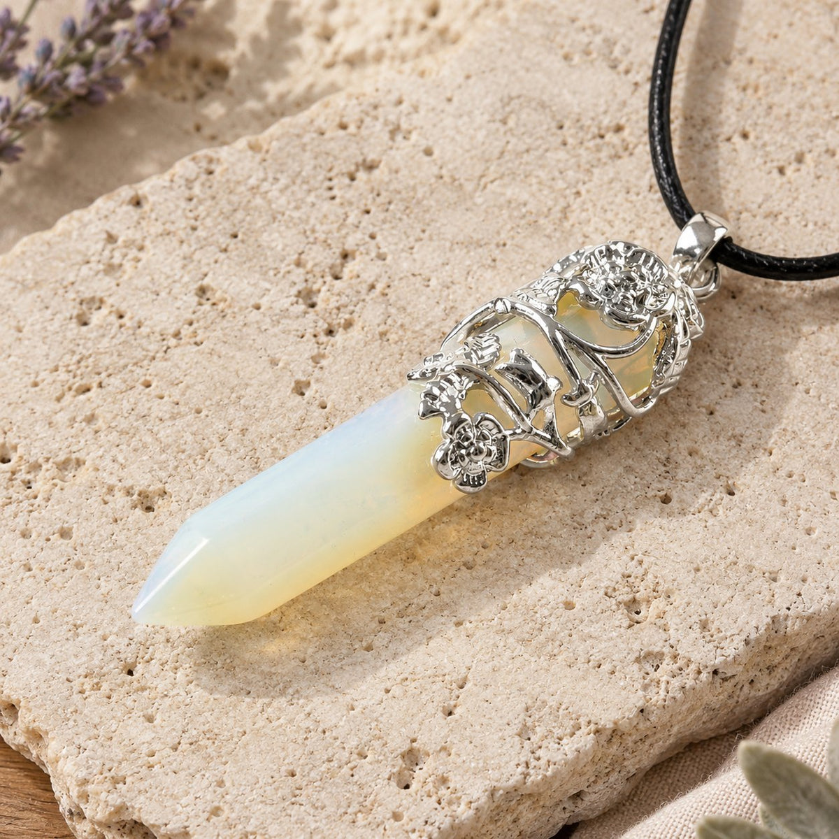 Opalite Healing Crystal Pendant for Spiritual Protection, pendant lying at an angle showing the floral cage