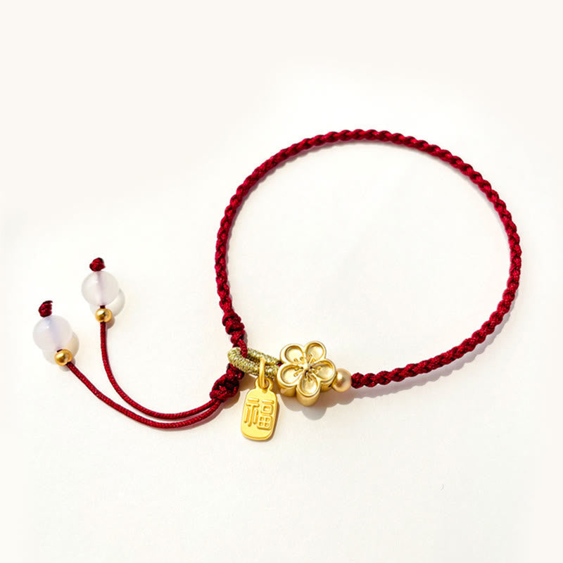 Bracelet en fil rouge avec breloque Fu et détail fleur de pêcher
