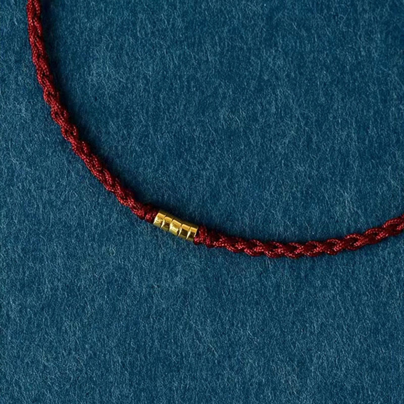Bracelet de cheville porte-bonheur en perles dorées à fil rouge