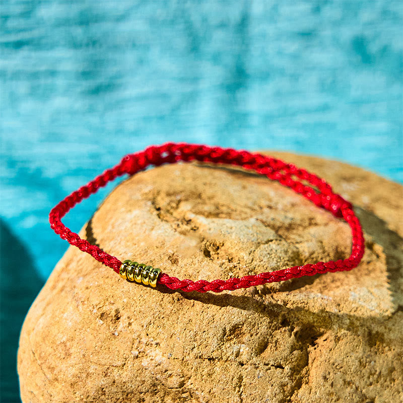 Bracelet de cheville porte-bonheur en perles dorées à fil rouge