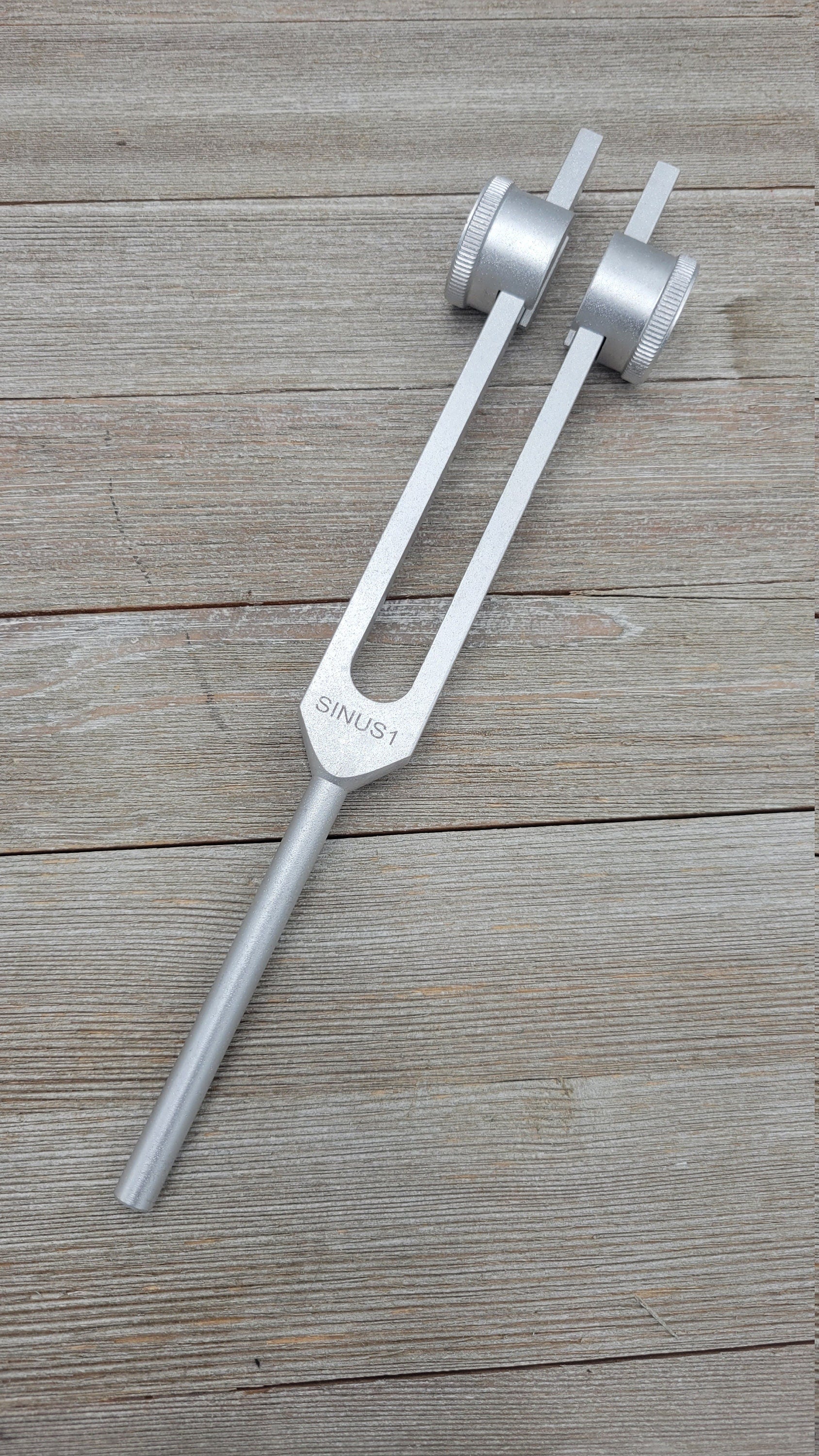 Silver tuning fork with adjustable resonator weights for sinus relief therapy