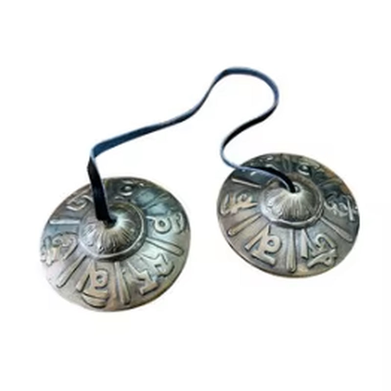 Tibetan Tingsha cymbals connected by black cord for meditation and sound healing